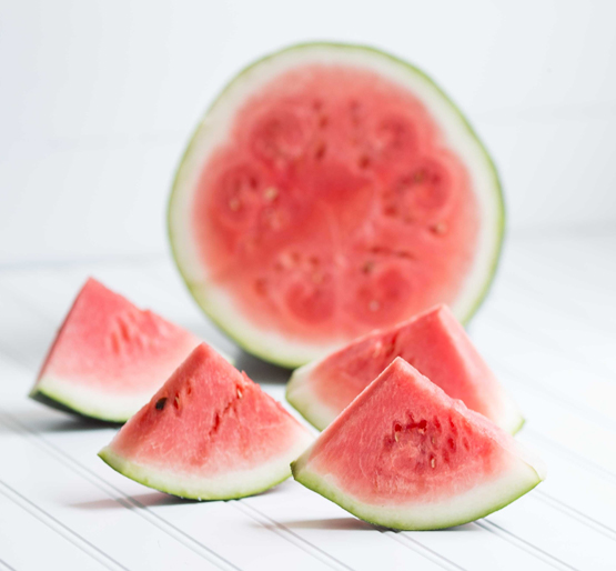 slices of watermelon in front of half watermelon